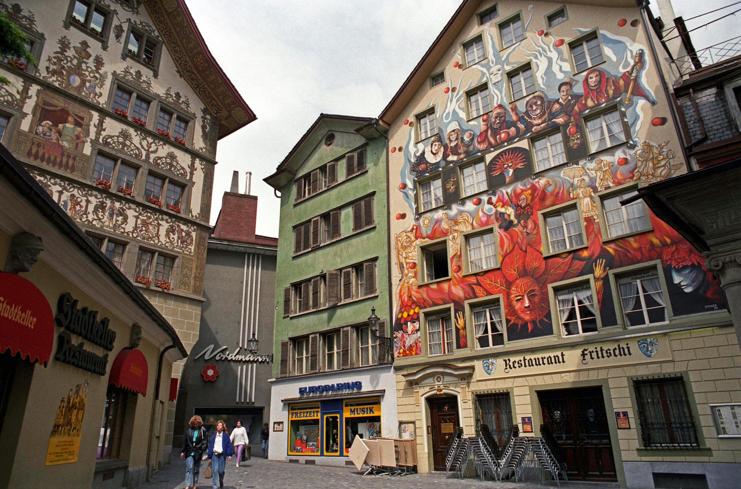 Vivid murals and architecture on a charming street in Lucerne, Switzerland.